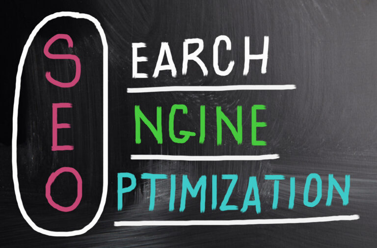 A single person stands before a chalkboard with &quot;Search Engine Optimization&quot; written on it. Each initial is vertically highlighted in pink within an oval outline, effectively emphasizing the acronym SEO.